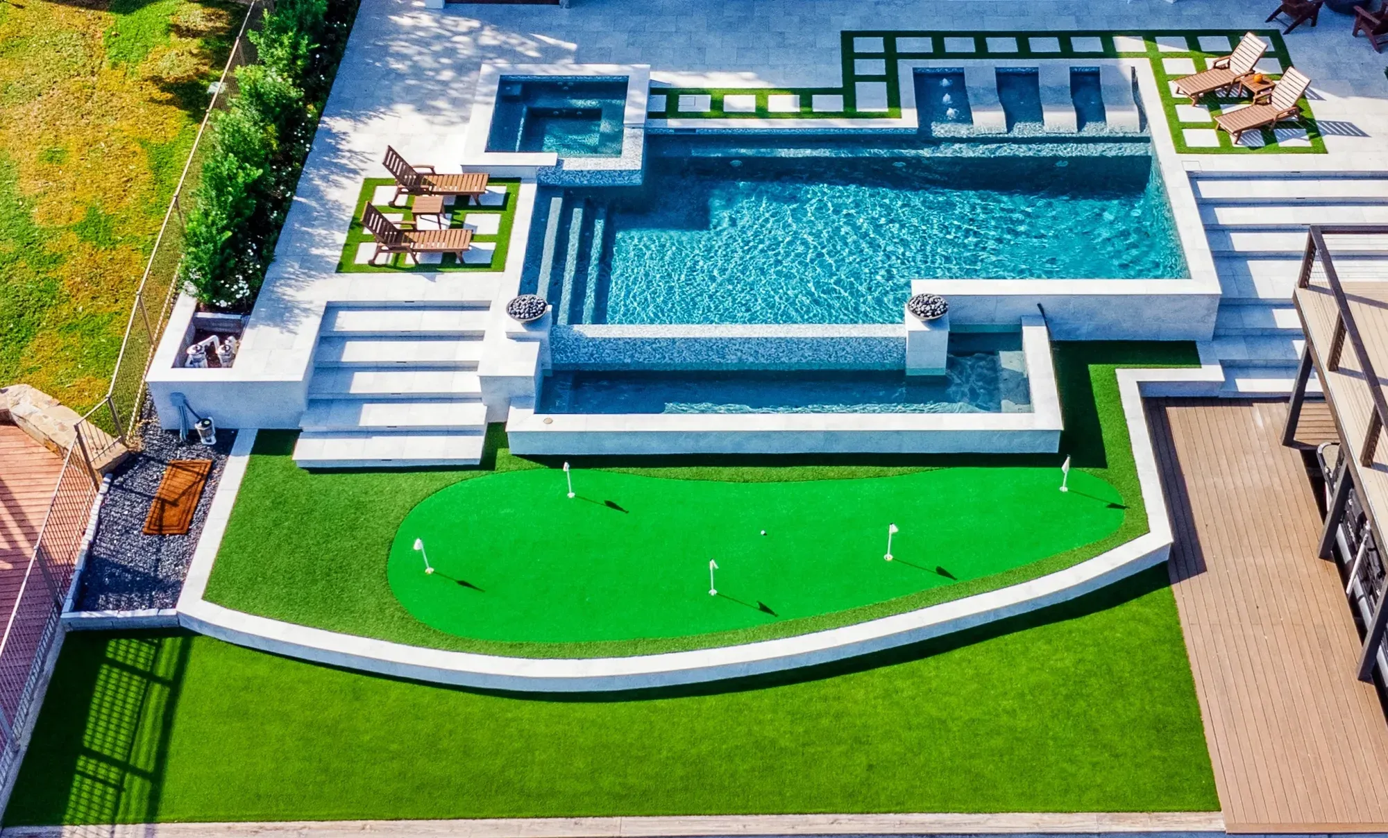 An aerial across the pool, spa and curved practice green to the timber deck