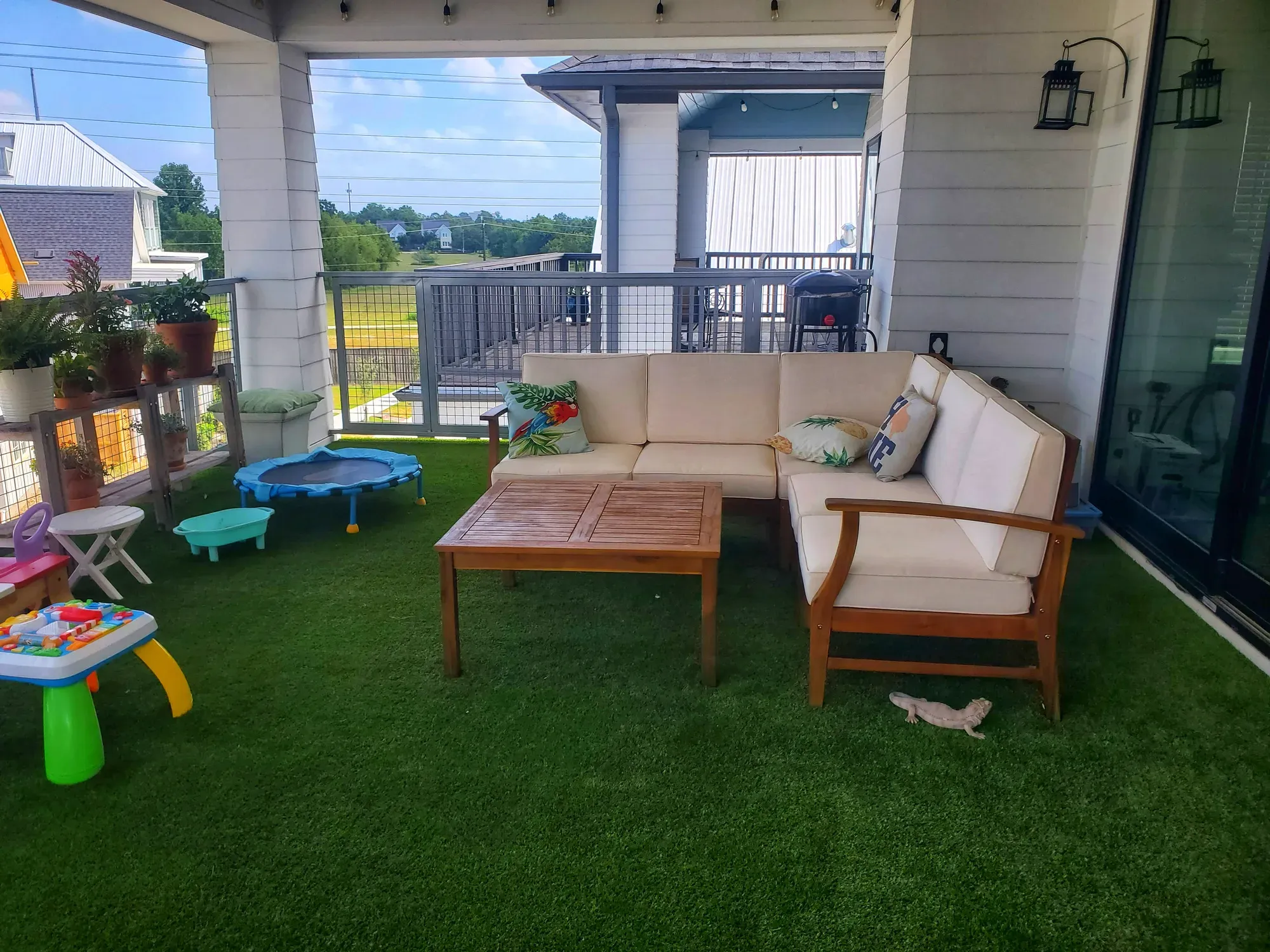 Artificial turf covering a high-rise balcony deck with a city view beyond the railing