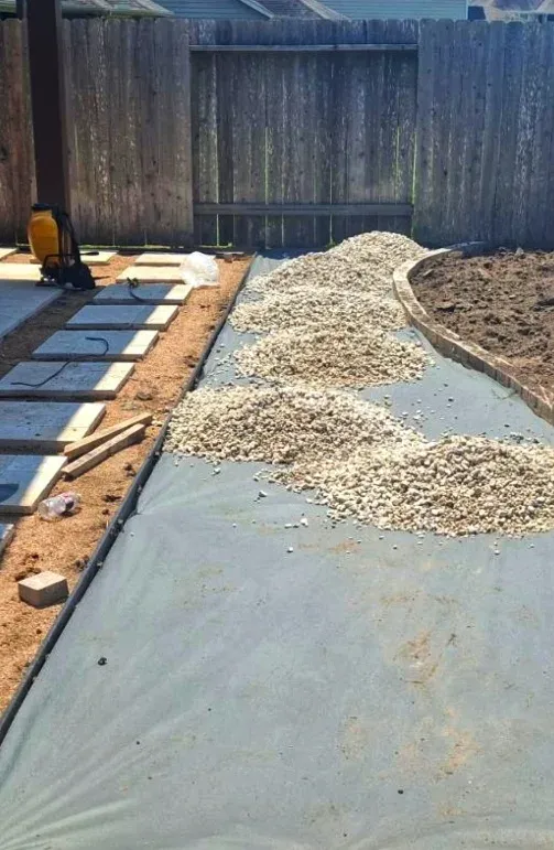 Base preparation under way: geotextile and aggregate spread across the excavated area