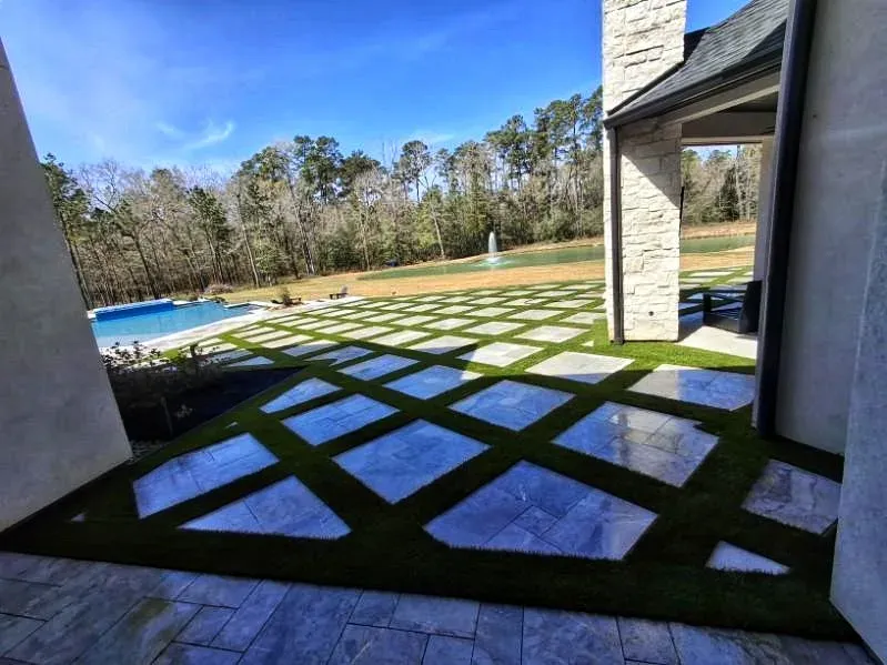 The diamond-patterned terrace from under the covered patio, looking out to the pool