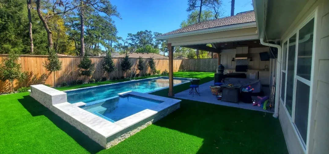 The freeform pool and cabana with artificial turf wrapping the deck