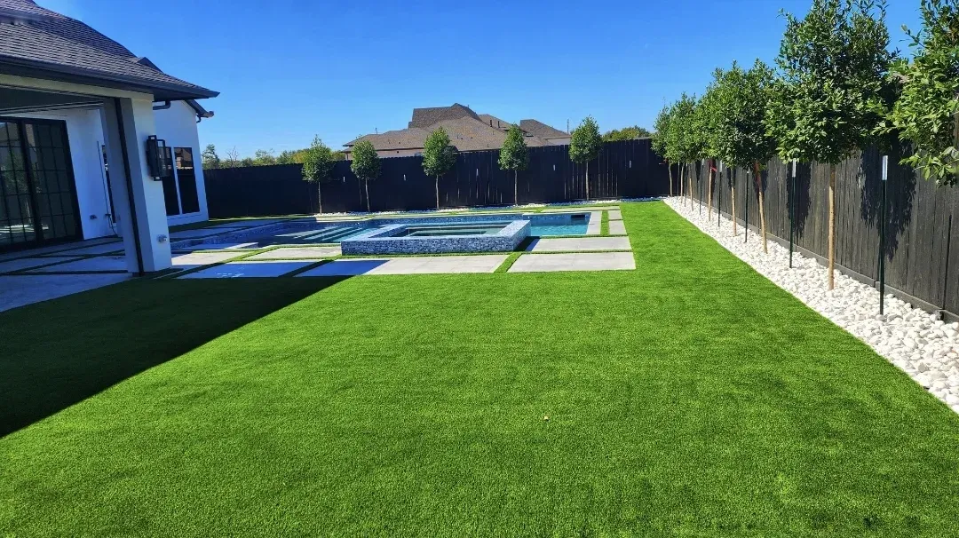 An artificial turf lawn running along the fence line behind a modern home